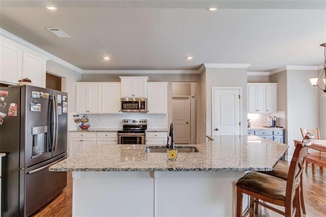 kitchen featuring a spacious island, stainless steel appliances, sink, and white cabinets