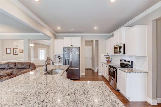 kitchen featuring appliances with stainless steel finishes, light stone countertops, sink, and white cabinets