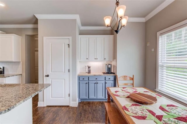 kitchen featuring crown molding, hanging light fixtures, dark hardwood / wood-style floors, light stone countertops, and white cabinets