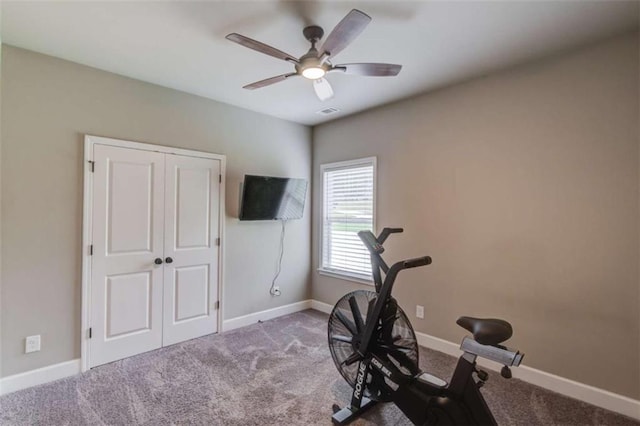 exercise area with ceiling fan and carpet