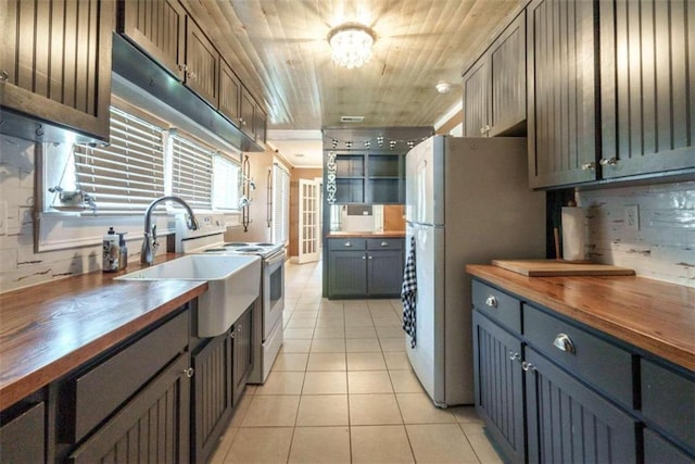 245 Alcovy St, Monroe, GA 30655 - kitchen with white appliances, butcher block counters, wood ceiling, light tile patterned floors, and decorative backsplash