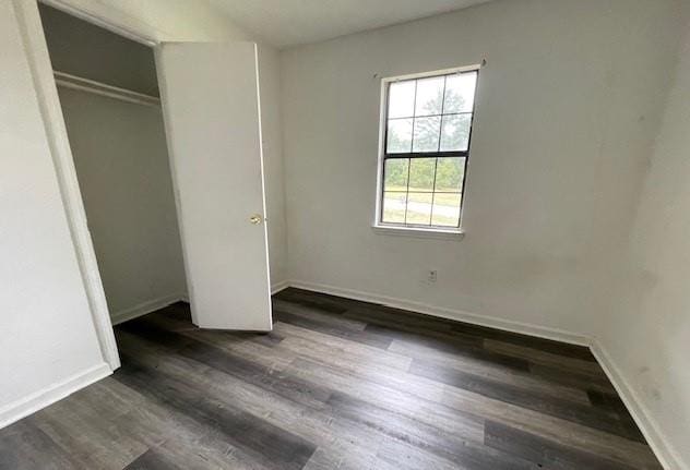 unfurnished bedroom featuring dark wood-type flooring and a closet