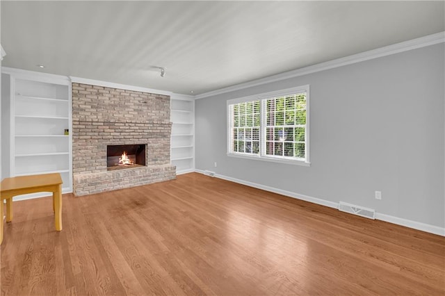 4331 E Kings Point Cir, Dunwoody, GA 30338 - unfurnished living room featuring built in features, a brick fireplace, ornamental molding, baseboards, and wood finished floors