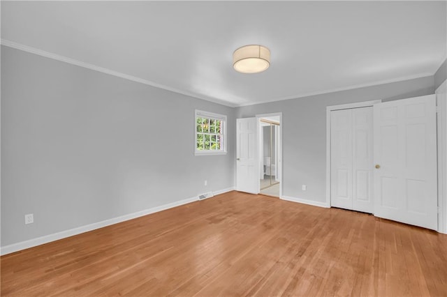 4331 E Kings Point Cir, Dunwoody, GA 30338 - unfurnished bedroom with crown molding, light wood-style floors, baseboards, and a closet
