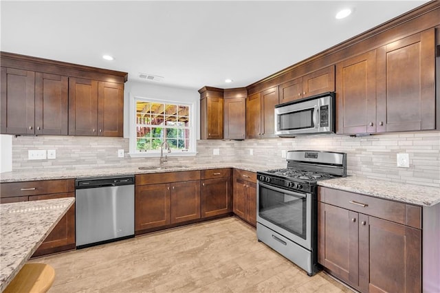 4331 E Kings Point Cir, Dunwoody, GA 30338 - kitchen featuring stainless steel appliances, a sink, light stone counters, tasteful backsplash, and recessed lighting