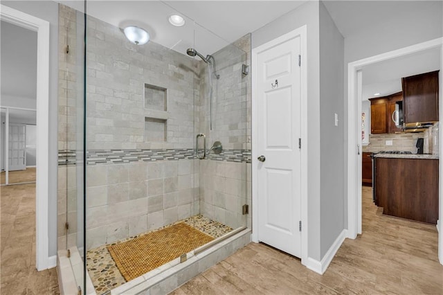 4331 E Kings Point Cir, Dunwoody, GA 30338 - bathroom featuring a stall shower, recessed lighting, baseboards, backsplash, and wood finished floors