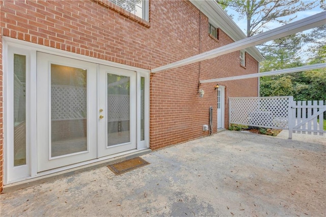 4331 E Kings Point Cir, Dunwoody, GA 30338 - view of exterior entry with brick siding, a patio, fence, and french doors