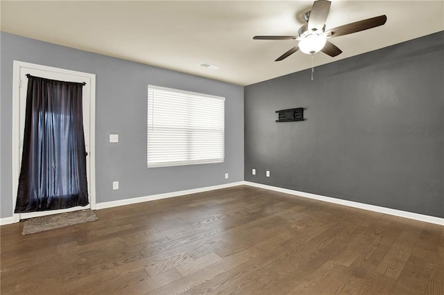 spare room with dark hardwood / wood-style flooring and ceiling fan