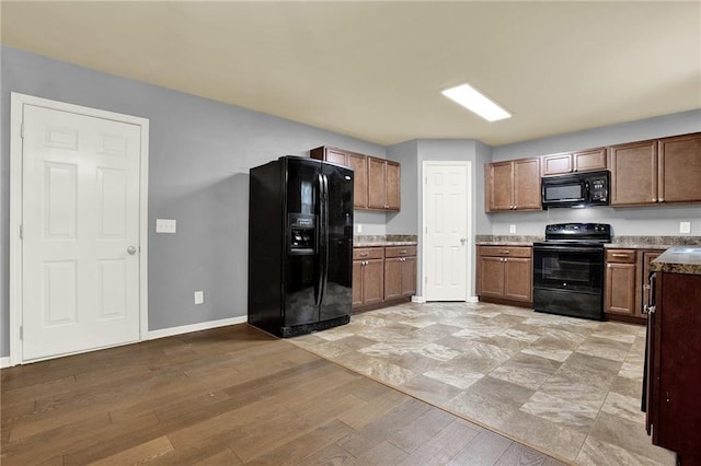 kitchen with black appliances and light hardwood / wood-style floors