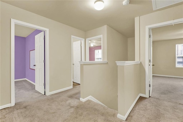 hallway featuring light carpet and plenty of natural light