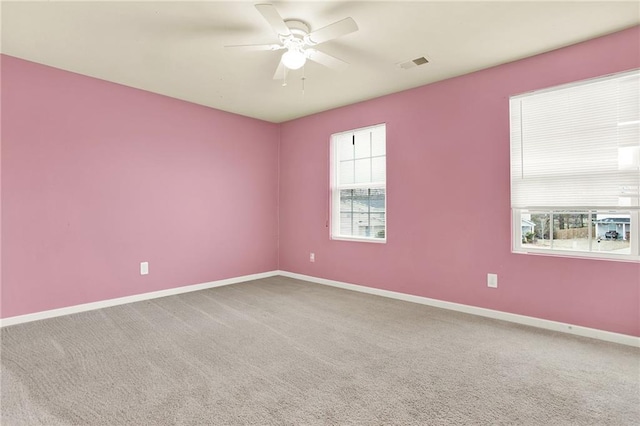 empty room featuring ceiling fan and carpet