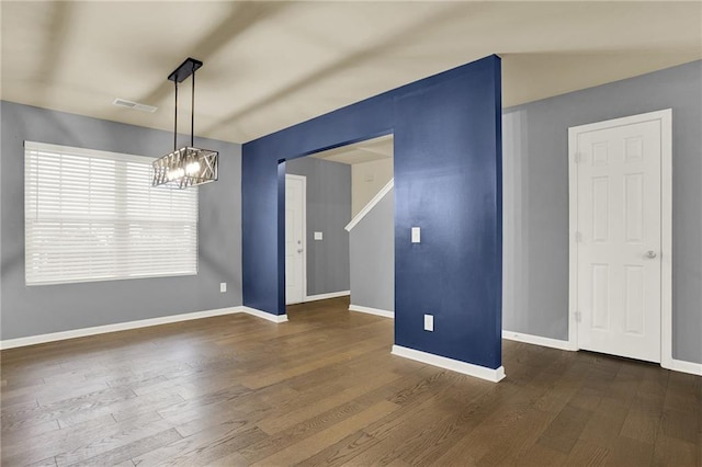 empty room featuring dark hardwood / wood-style floors and a chandelier