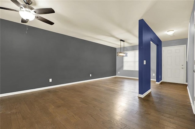 unfurnished room featuring dark hardwood / wood-style flooring and ceiling fan with notable chandelier