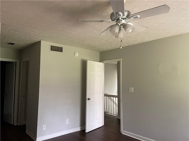 unfurnished bedroom featuring a textured ceiling, ceiling fan, and dark hardwood / wood-style floors