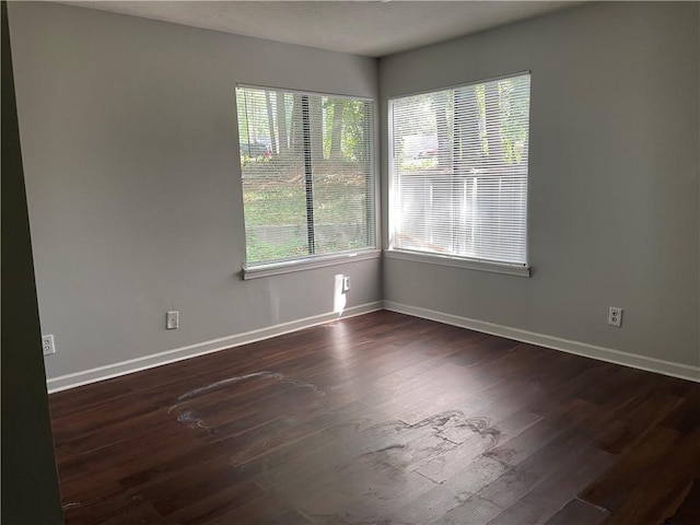 unfurnished room with dark wood-type flooring