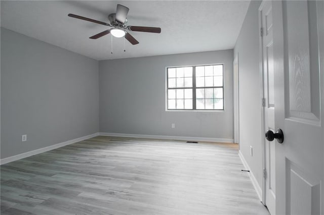 unfurnished room featuring a ceiling fan, baseboards, and light wood finished floors