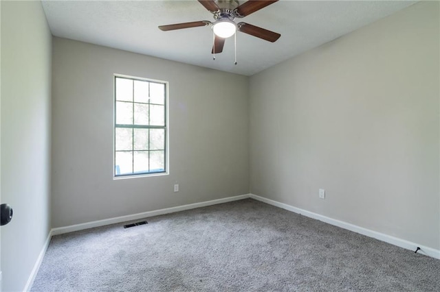 carpeted empty room with baseboards, visible vents, and ceiling fan