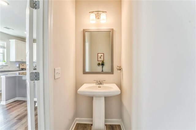 bathroom with hardwood / wood-style floors and backsplash