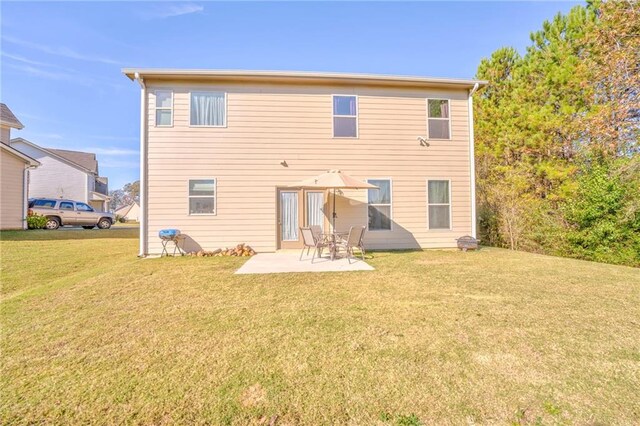 rear view of house featuring a yard and a patio