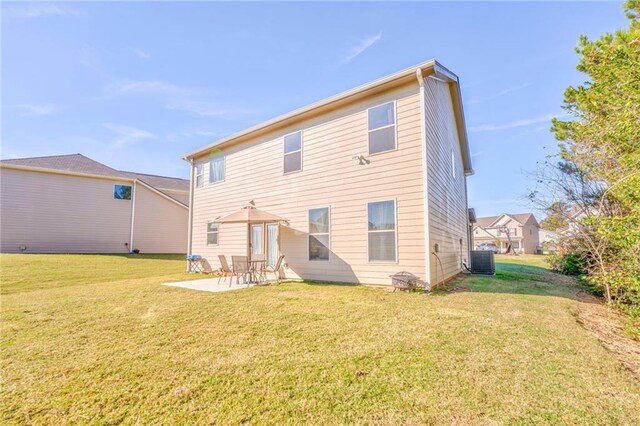 rear view of property featuring cooling unit, a yard, and a patio