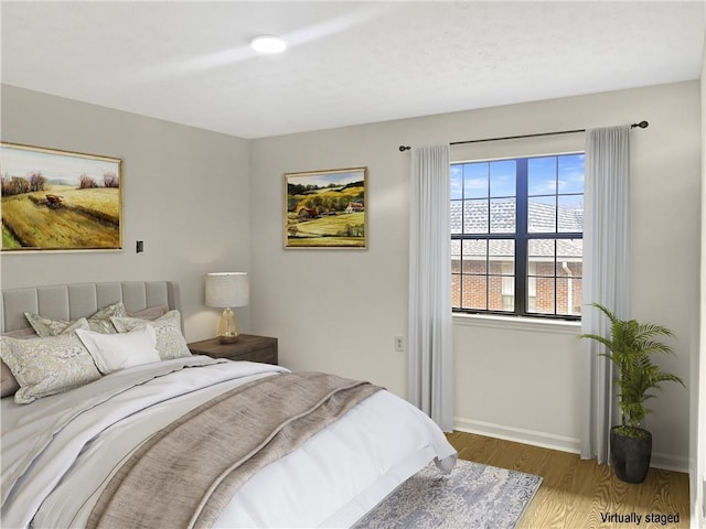 bedroom featuring baseboards and wood finished floors