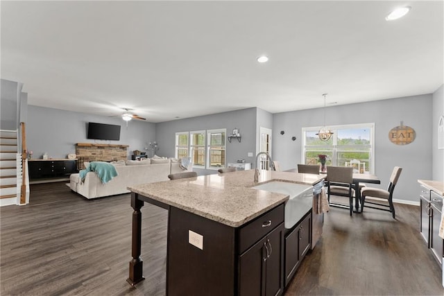 kitchen featuring dark brown cabinetry, dark wood-style flooring, a kitchen bar, ceiling fan with notable chandelier, and recessed lighting
