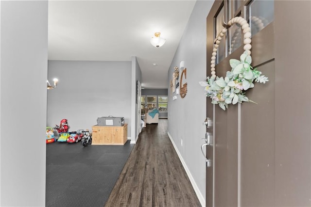 foyer featuring baseboards and wood finished floors