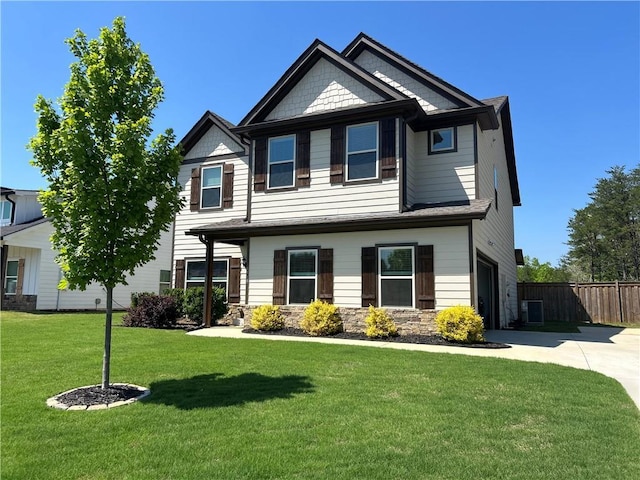craftsman-style home featuring fence, central AC, stone siding, a front yard, and driveway