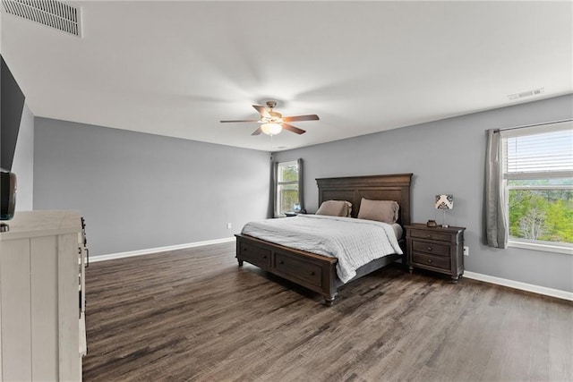 bedroom featuring a ceiling fan, baseboards, visible vents, and wood finished floors