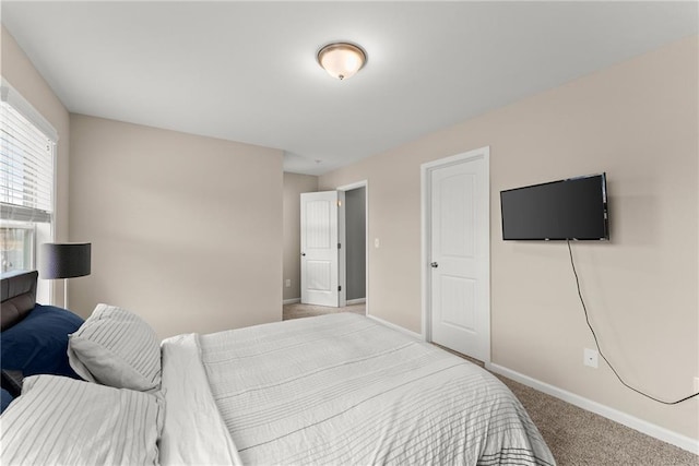 bedroom with baseboards and light colored carpet