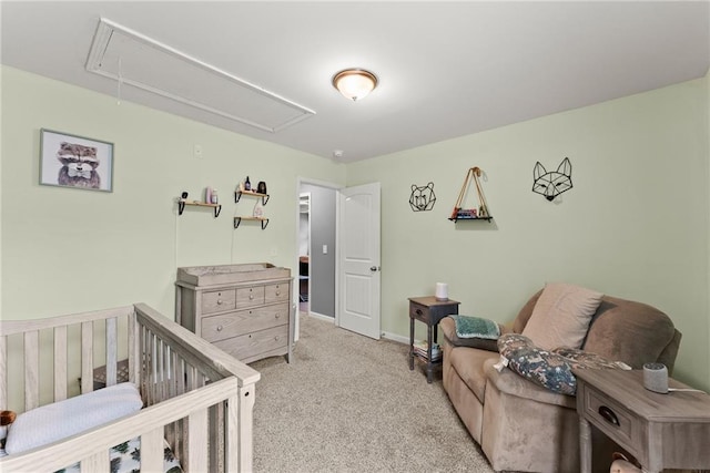 carpeted bedroom with baseboards, attic access, and a crib