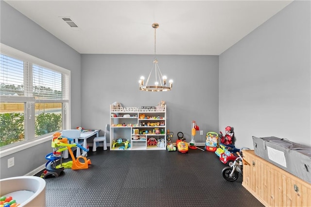 rec room with baseboards, visible vents, and a chandelier