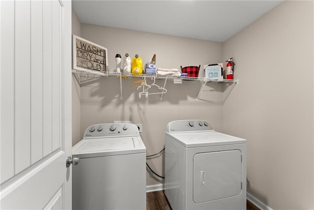 laundry room with laundry area, dark wood finished floors, baseboards, and washing machine and clothes dryer
