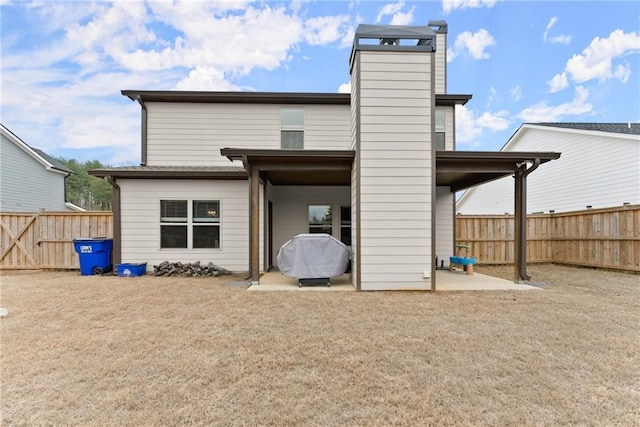 back of house featuring a fenced backyard and a chimney