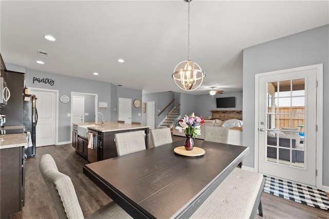dining room featuring dark wood-type flooring, recessed lighting, baseboards, and stairway