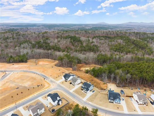aerial view featuring a wooded view and a mountain view