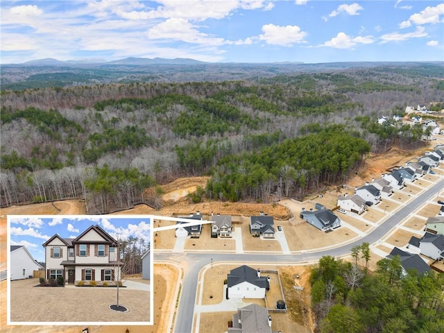 aerial view with a wooded view and a mountain view