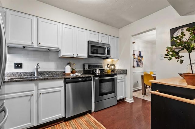 3701 Essex Ave Unit 2, Atlanta, GA 30339 - kitchen featuring appliances with stainless steel finishes, a sink, dark wood-style flooring, dark stone countertops, and backsplash