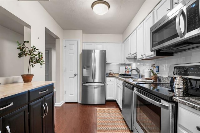 3701 Essex Ave Unit 2, Atlanta, GA 30339 - kitchen with stainless steel appliances, a sink, white cabinets, tasteful backsplash, and dark wood-style floors