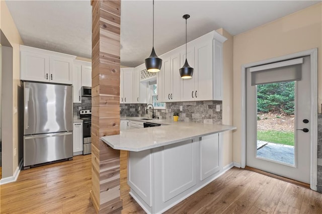 2680 Pine Tree Rd NE Unit 2, Atlanta, GA 30324 - kitchen featuring appliances with stainless steel finishes, light countertops, tasteful backsplash, light wood-style flooring, and white cabinetry
