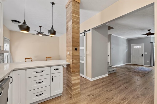 2680 Pine Tree Rd NE Unit 2, Atlanta, GA 30324 - kitchen featuring ceiling fan, a barn door, open floor plan, white cabinetry, and ornamental molding