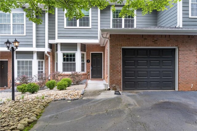 2680 Pine Tree Rd NE Unit 2, Atlanta, GA 30324 - view of exterior entry with asphalt driveway, brick siding, and a garage