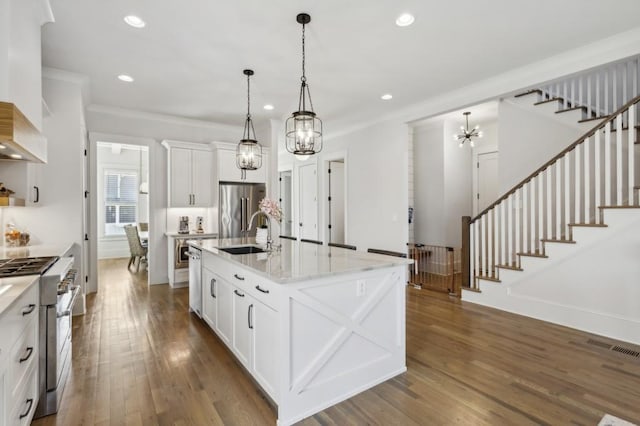 kitchen featuring a kitchen island with sink, dark wood-type flooring, high end appliances, and decorative light fixtures