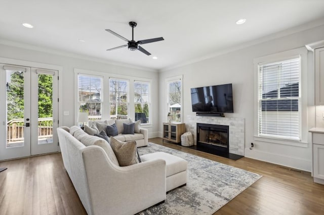 living room featuring french doors, light hardwood / wood-style flooring, crown molding, and ceiling fan