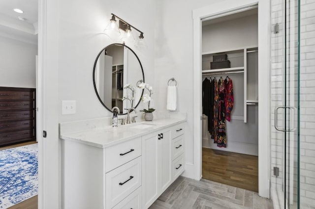 bathroom with an enclosed shower, vanity, and hardwood / wood-style flooring