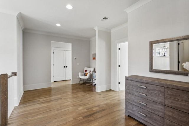 hallway with crown molding and light wood-type flooring