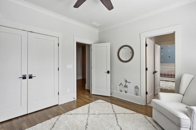 living area featuring ornamental molding, ceiling fan, and dark wood-type flooring