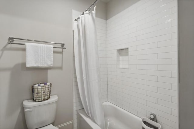 bathroom featuring shower / bathtub combination with curtain and toilet