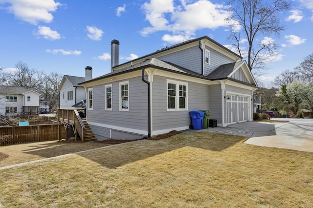 rear view of property with a garage and a yard