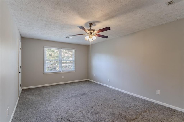 spare room featuring a textured ceiling, carpet flooring, and ceiling fan